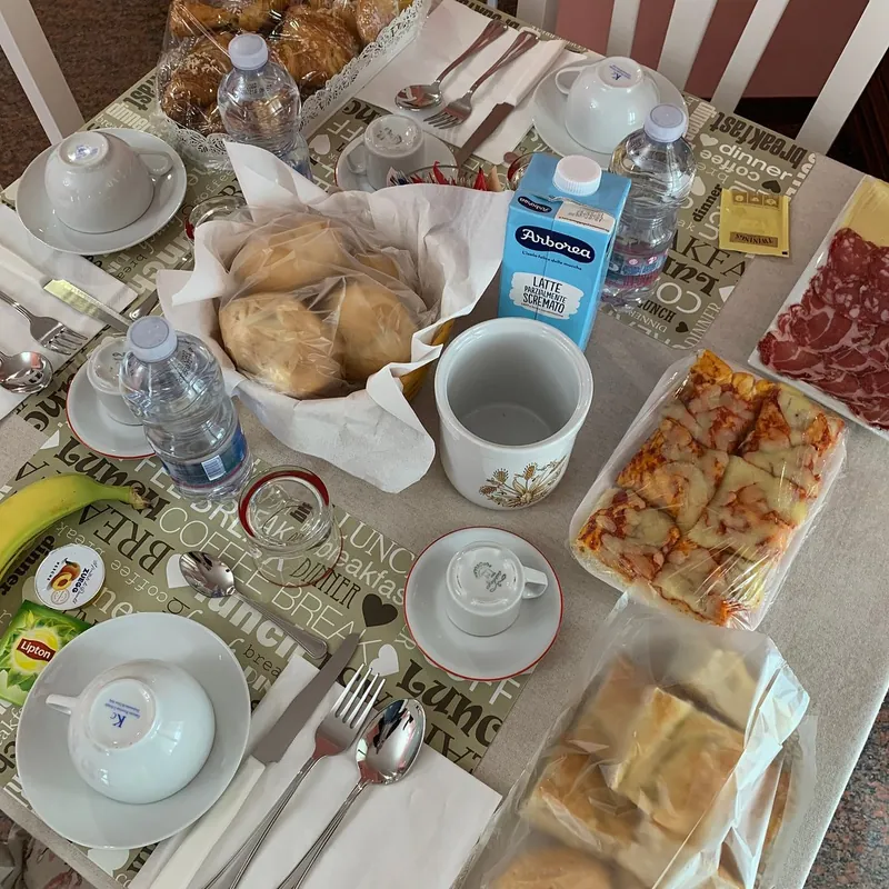 Colazione: tavola apparecchiata con pane, salumi e dolci